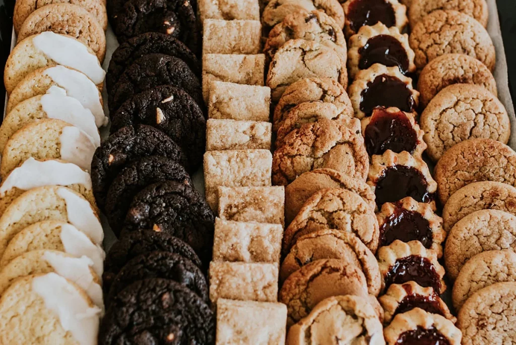An array of gourmet cookies in different flavors, arranged in neat rows on a tray