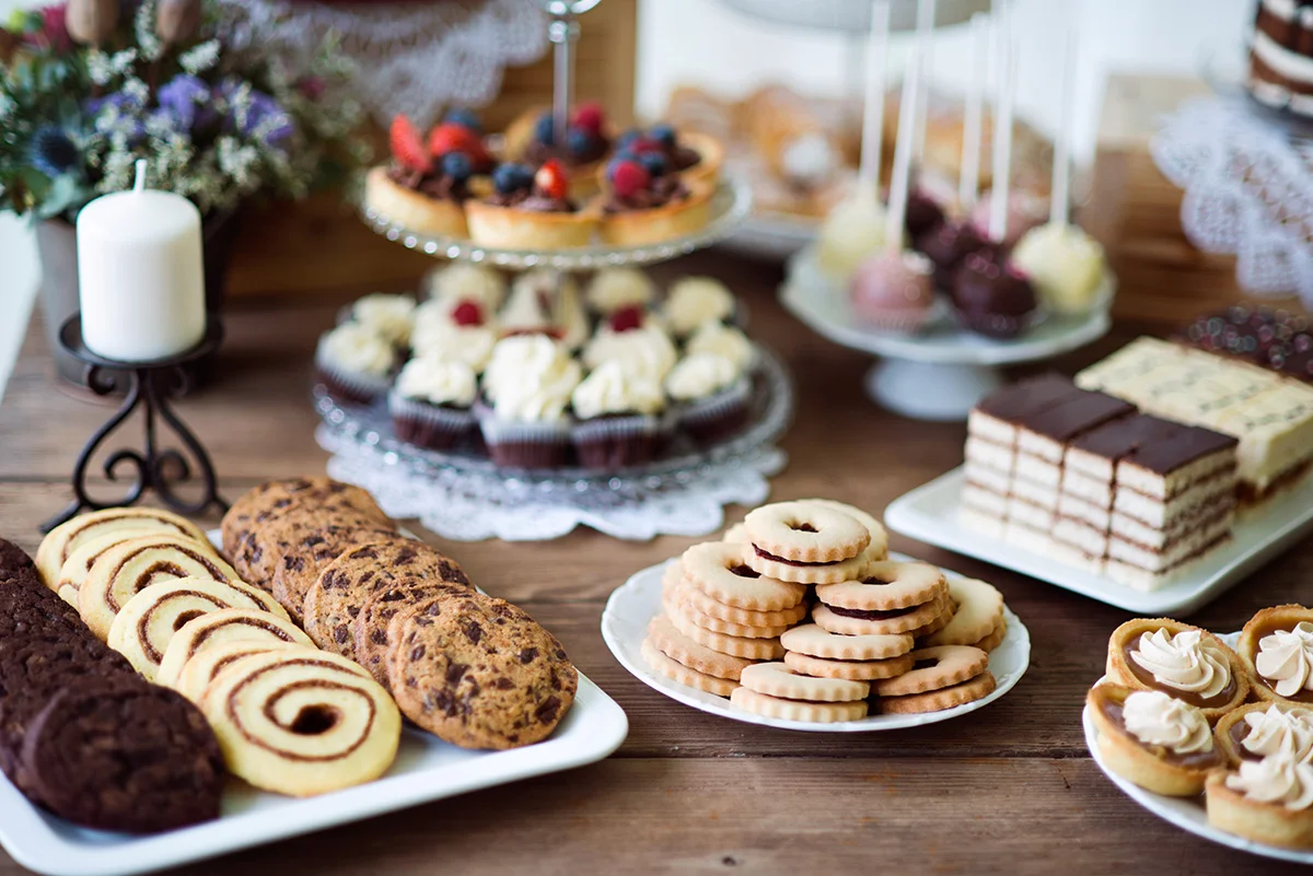 A wedding cookie table display, filled with various gourmet cookies on tiered stands